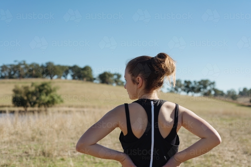 behind view of teen girl going for a morning jog - Australian Stock Image