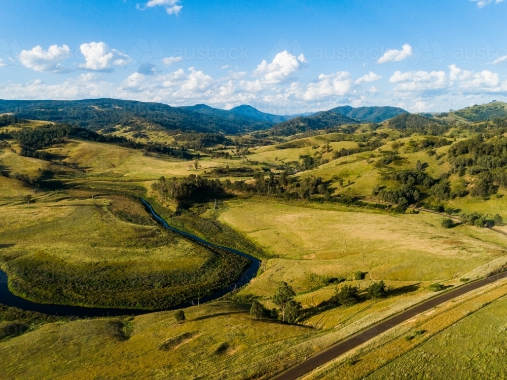 Bendy river winding through valley towards lake - Australian Stock Image