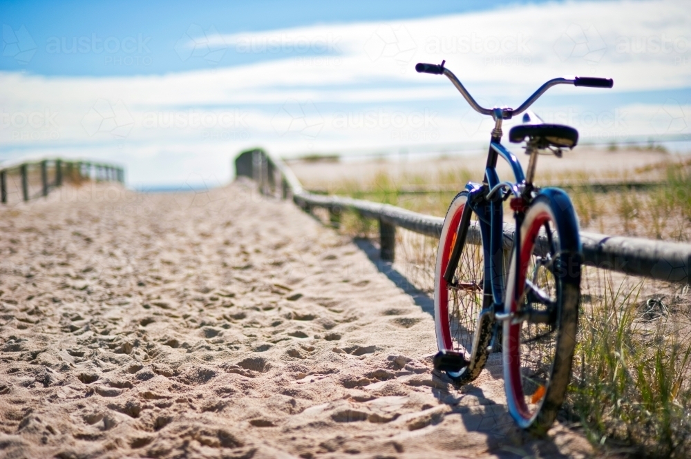 Bicycle at the end of the beach track leading to the sea. - Australian Stock Image