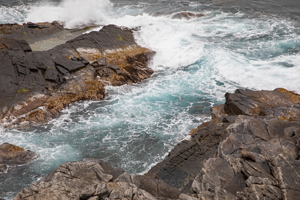 Big waves crashing against the jagged rocks - Australian Stock Image