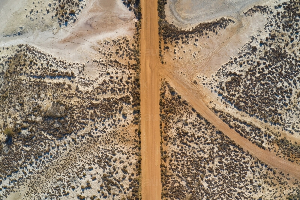 Bird's eye view of a section of dusty gravel road between dry salt lakes in Western Australia. - Australian Stock Image