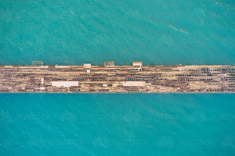 Bird's eye view of an old abandoned jetty in turquoise ocean water  - Kwinana Bulk Jetty - Australian Stock Image