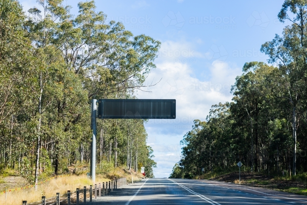 blank overhead digital sign above empty road - Australian Stock Image