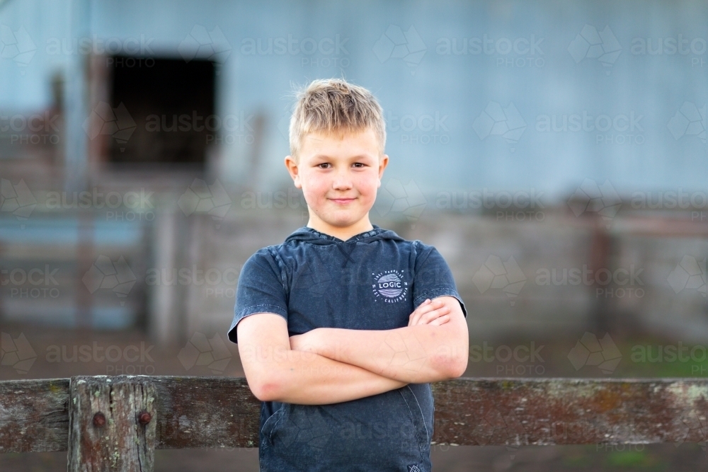 Blonde boy outdoors with arms crossed - Australian Stock Image
