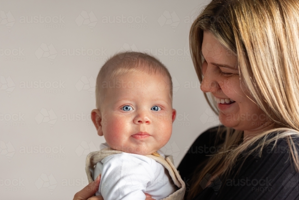 Blue eyed aboriginal baby boy with mother in home - Australian Stock Image