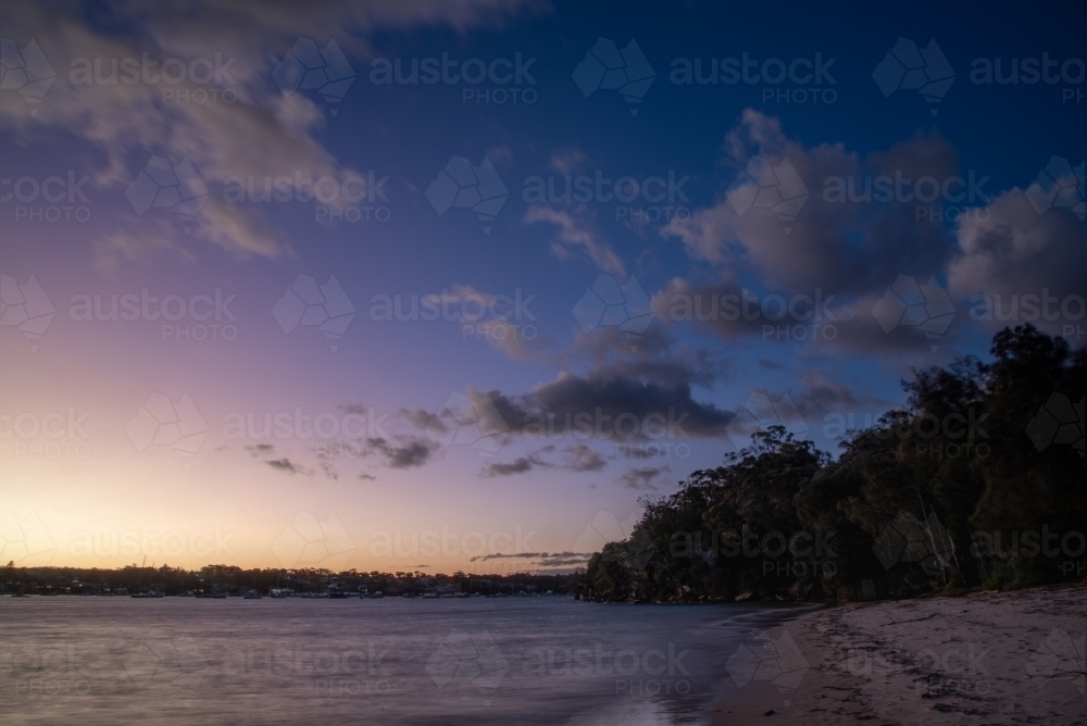 Blue hour photo of beach and bay with clouds in the sky - Australian Stock Image