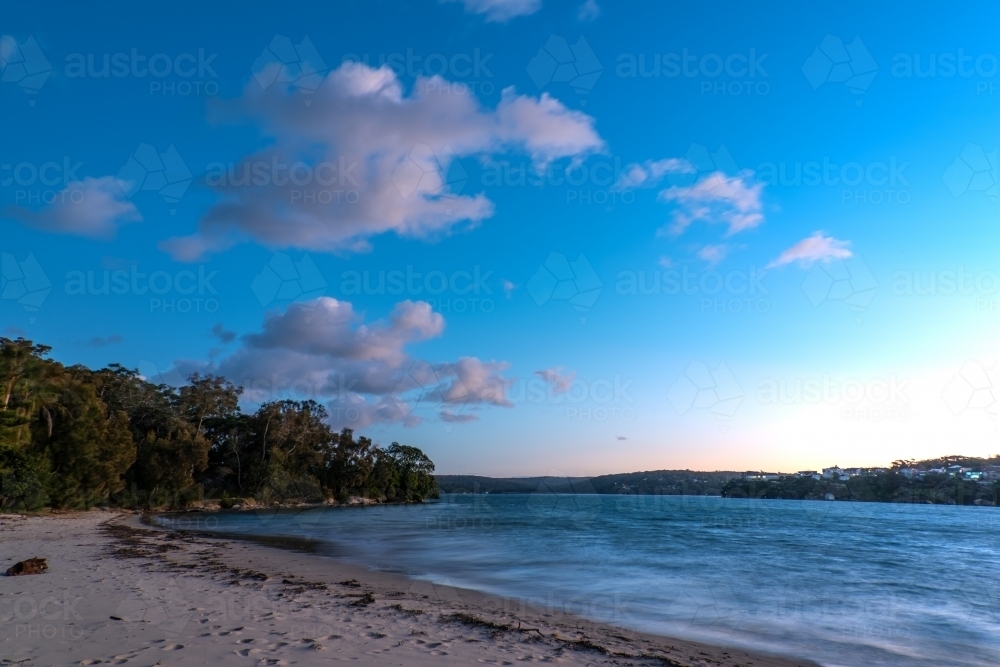 Blue hour photo of beach and bay with clouds in a blue sky - Australian Stock Image