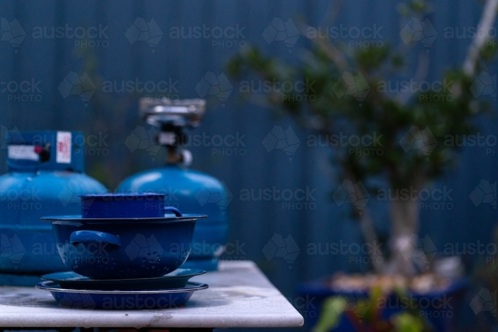 Blue objects on table in front of blue fence - Australian Stock Image