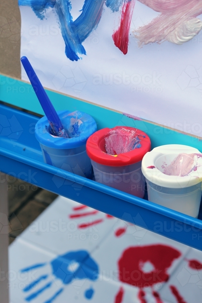 Blue red white paint pots with brush - Australian Stock Image