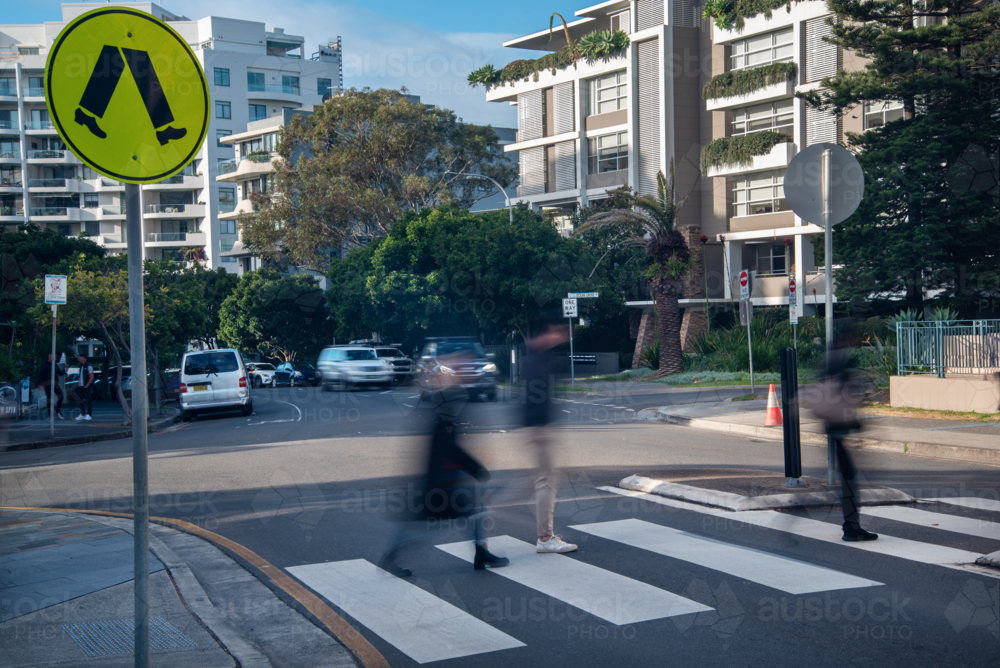 Blurry pedestrians walking across a pedestrian crossing - Australian Stock Image