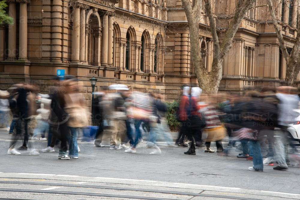 Blurry people crossing the road in front of historic Town Hall - Australian Stock Image