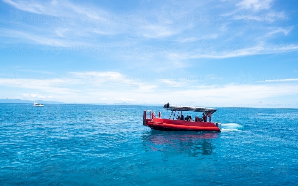 boat riding at the great barrier reef over blue water - Australian Stock Image