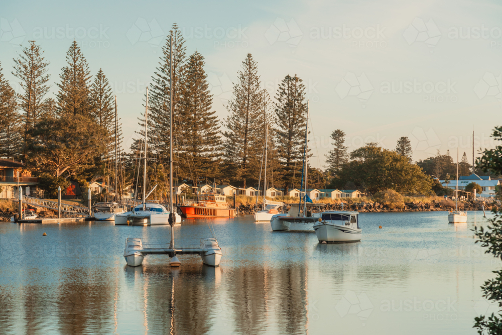 Boats and yachts anchored along the Clarence River beside caravan park at Iluka, New South Wales - Australian Stock Image
