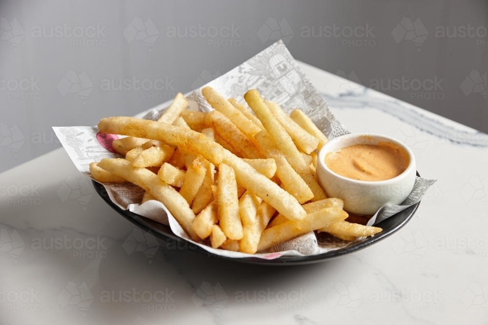 Bowl of hot chips with dipping sauce - Australian Stock Image