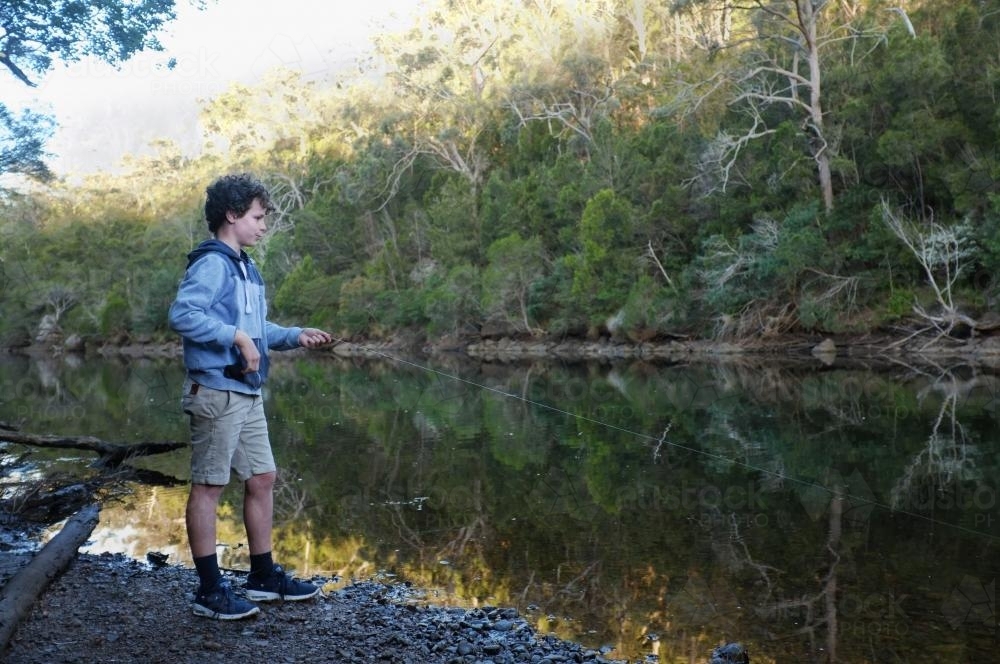 Boy hand fishing in river - Australian Stock Image
