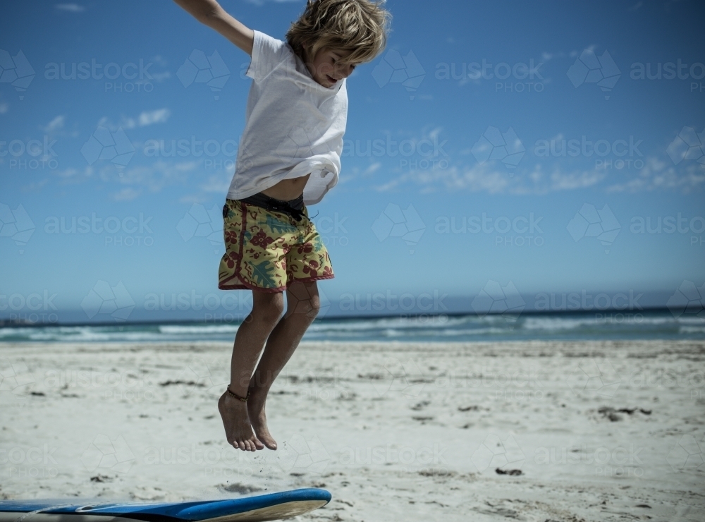 Boy jumping on the beach - Australian Stock Image