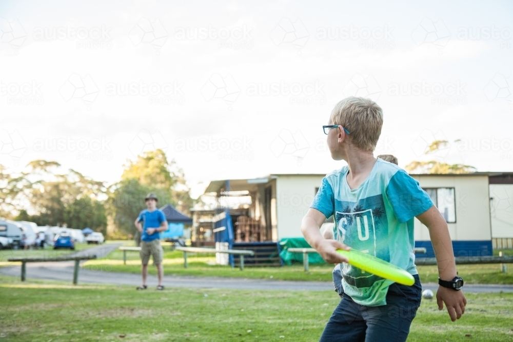 Boy playing frisbee at holiday park - Australian Stock Image