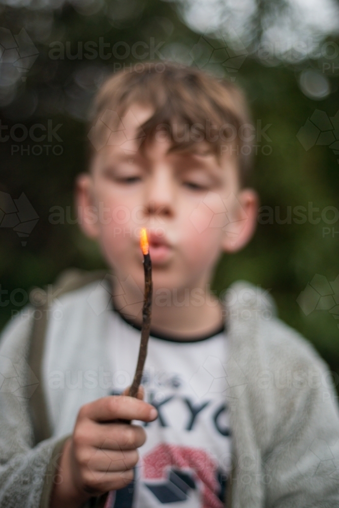 Boy playing with campfire - Australian Stock Image