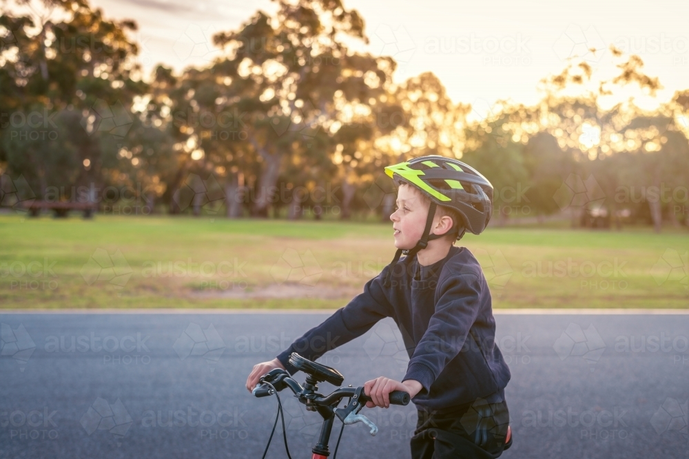 Boy riding his bicycle at sunset at Adelaide Park Lands - Australian Stock Image