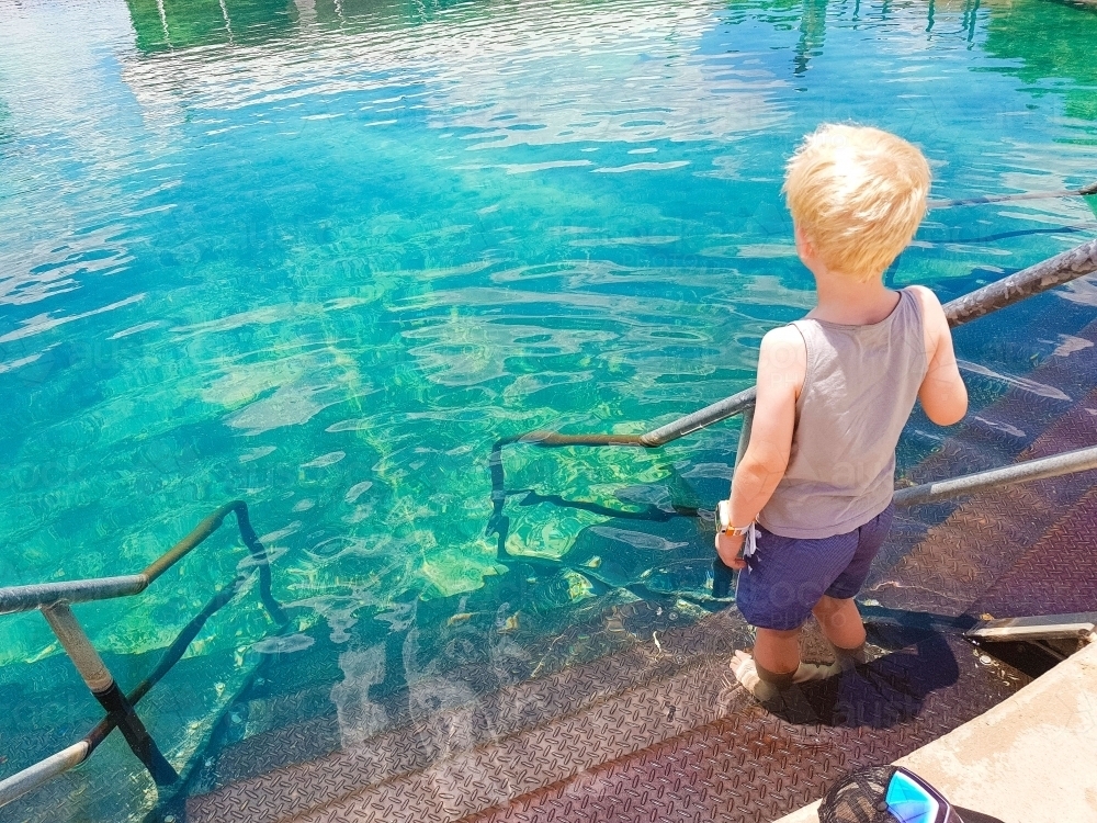 Boy standing on steps of the Lightning Ridge Hot Springs - Australian Stock Image