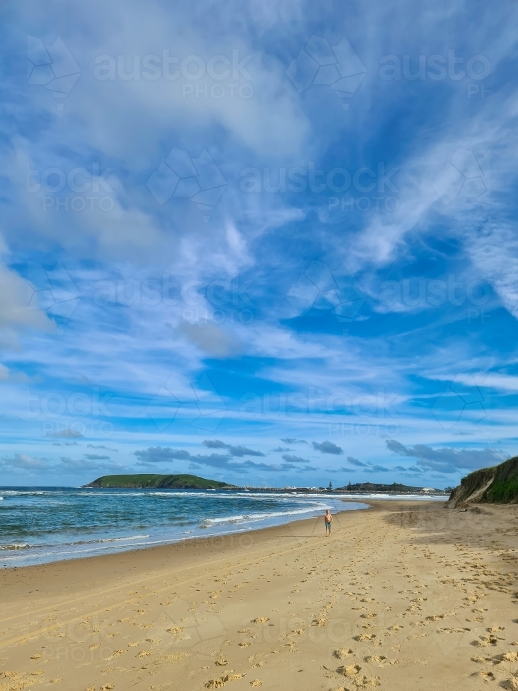 Boy walking along beach in Coffs Harbour - Australian Stock Image