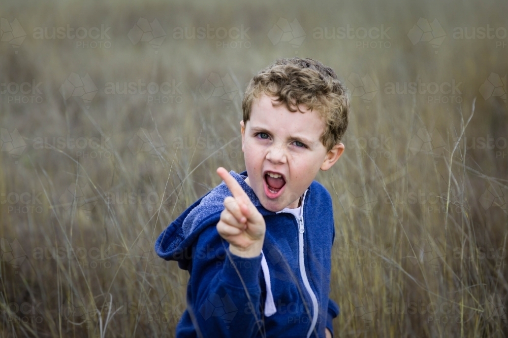 Boy with mouth open shaking finger - Australian Stock Image