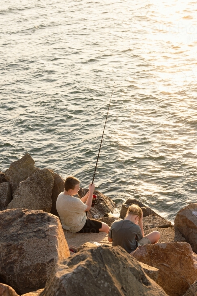 Image of Boys fishing from breakwall at Stockton Beach, NSW