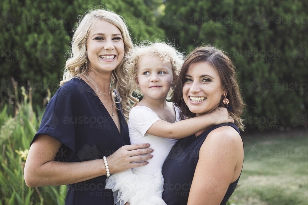 Bridesmaids with flower girl in garden at wedding - Australian Stock Image