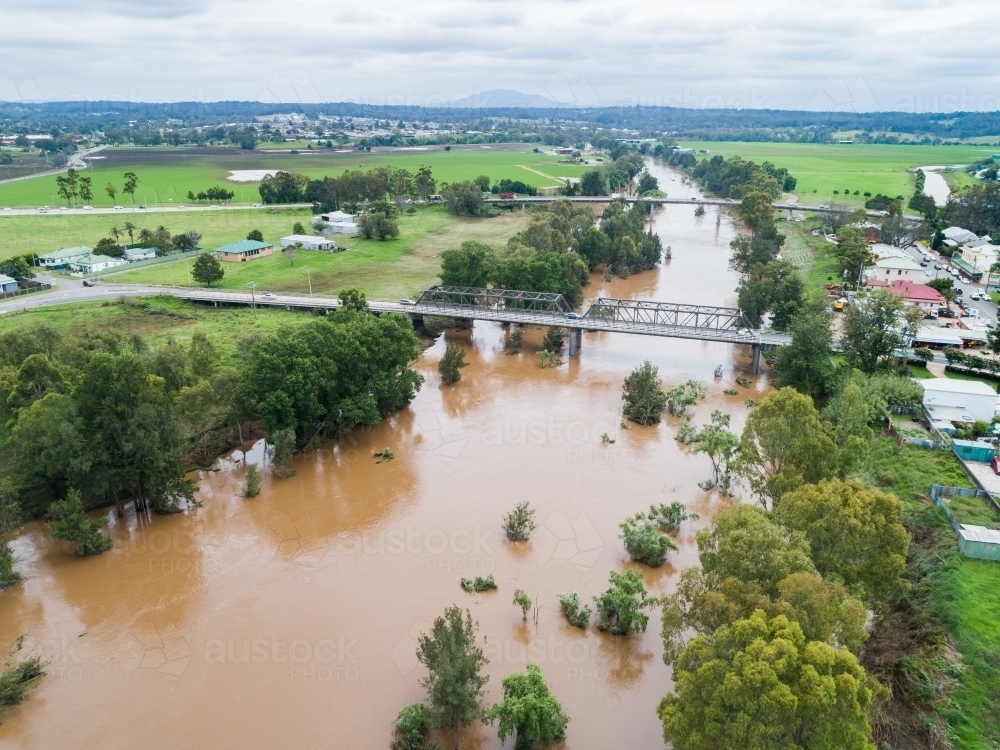 Bridge over river with receding floodwaters in flood aftermath - Australian Stock Image