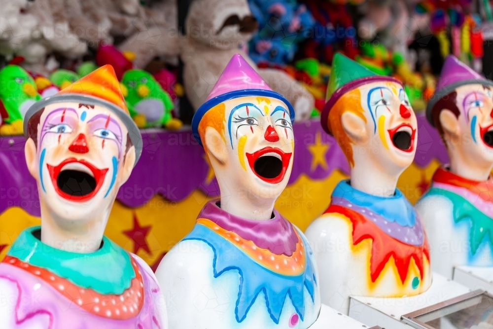 Brightly painted clowns at carnival sideshow alley - Australian Stock Image