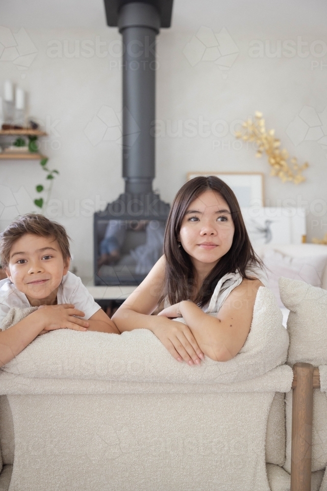 Brother and sister on couch at home together - Australian Stock Image