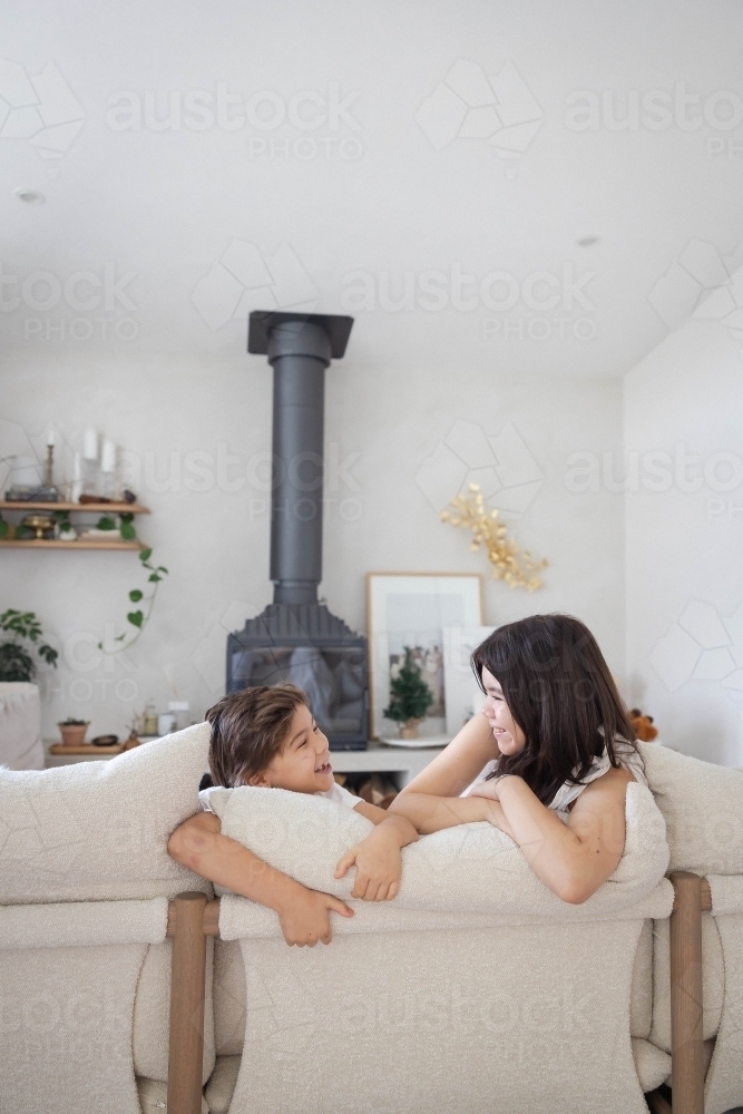 Brother and sister on couch at home together - Australian Stock Image