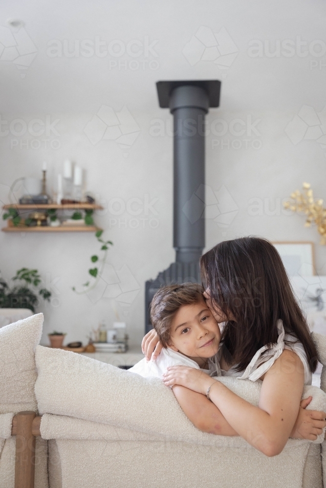Brother and sister on couch at home together - Australian Stock Image