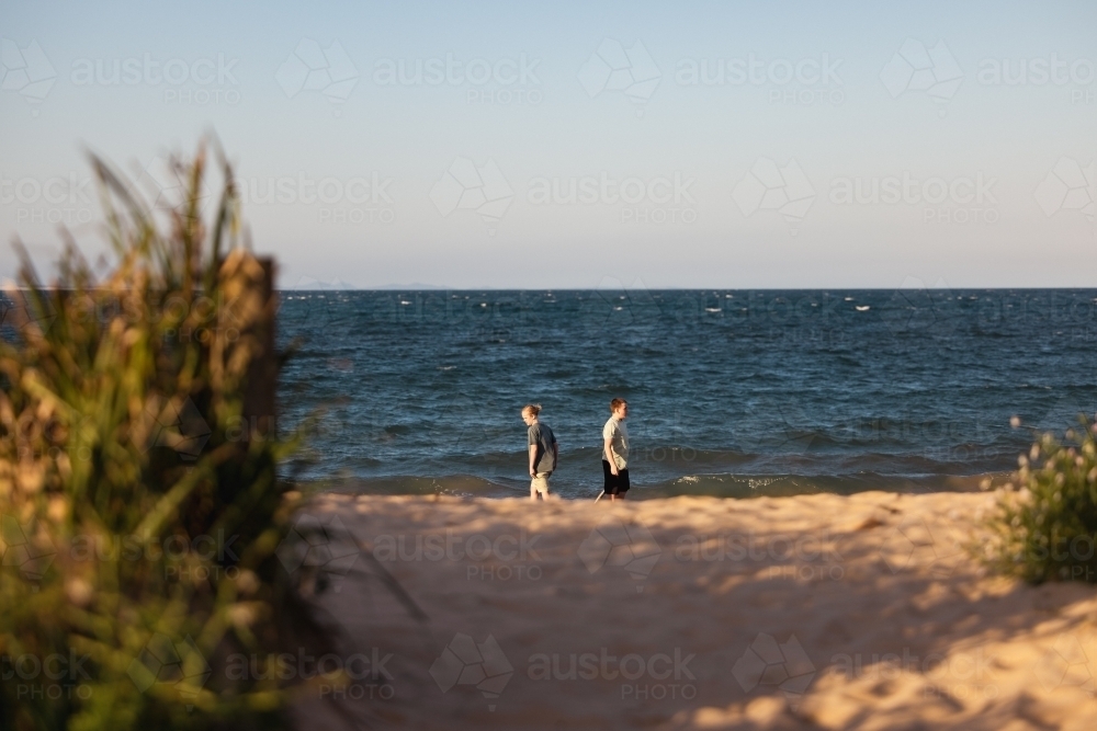 Brothers on the beach with sand pump. Teenage boys outdoors. - Australian Stock Image