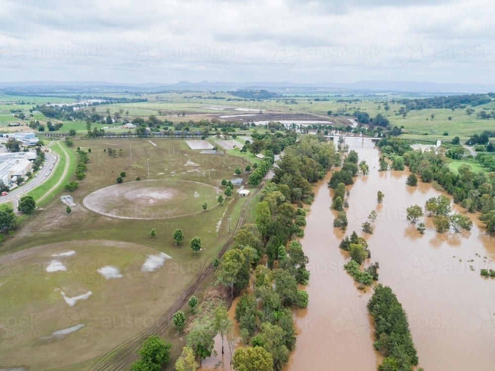 Brown floodwaters in Hunter River water falling after flood - Australian Stock Image