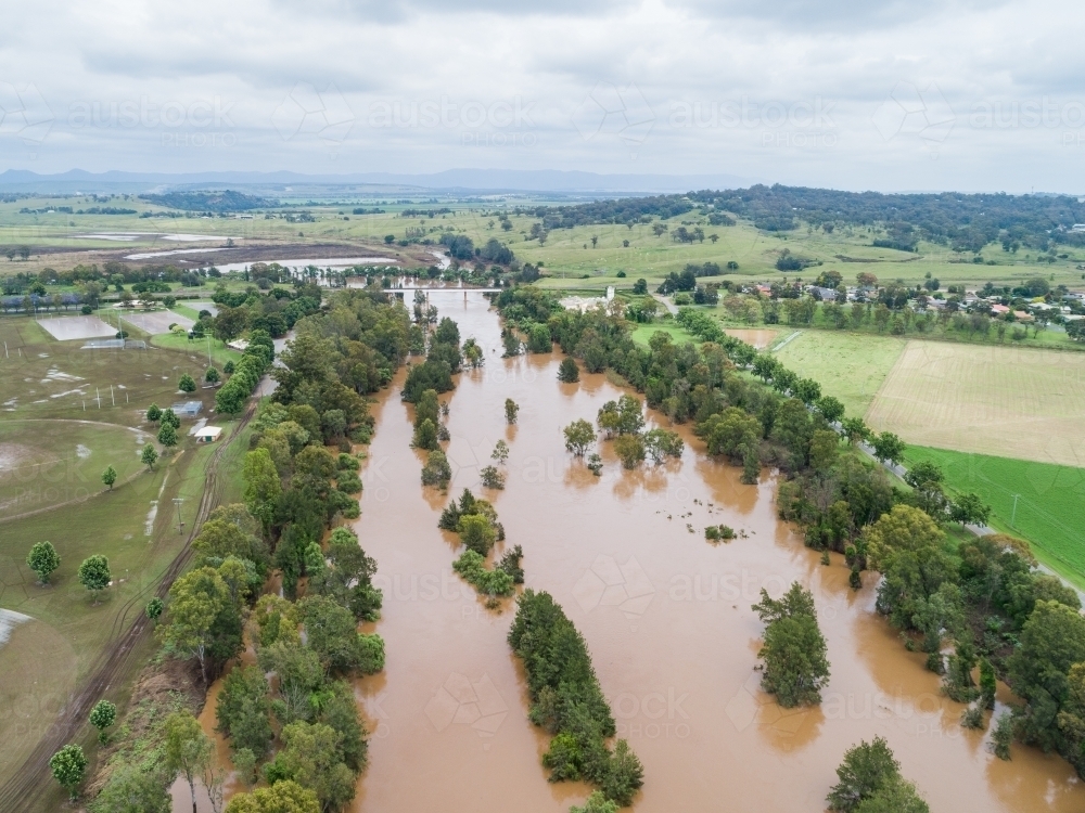 Brown floodwaters in Hunter River water falling after flood - Australian Stock Image