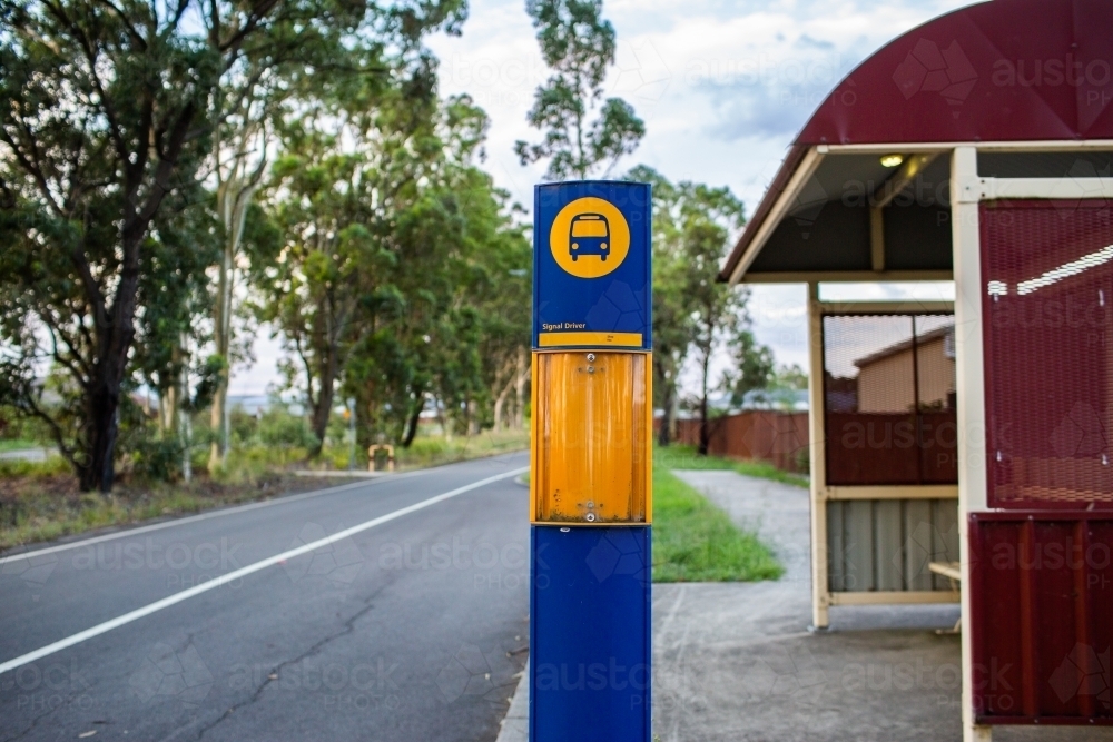 Bus stop shelter beside road with green strip - Australian Stock Image