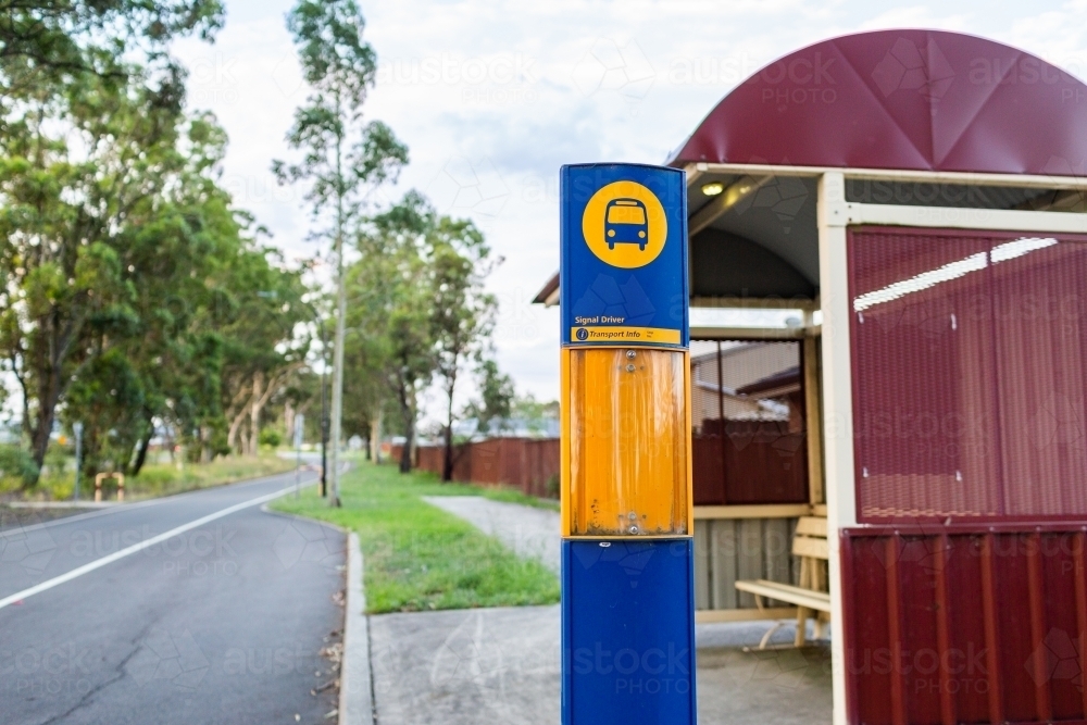 Bus stop shelter beside road with green strip - Australian Stock Image