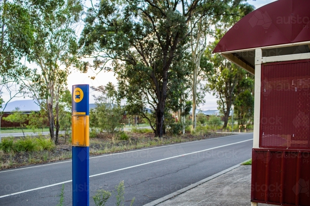 Bus stop shelter beside road with green strip - Australian Stock Image