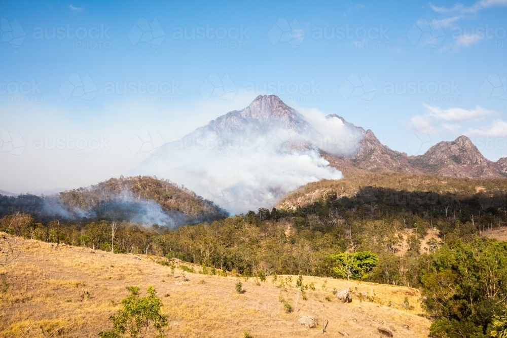 Bushfire smoke from a wildfire surrounds Mt Barney in the Scenic Rim. - Australian Stock Image