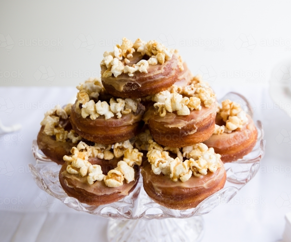 Cake stand filled with popcorn covered donuts - Australian Stock Image