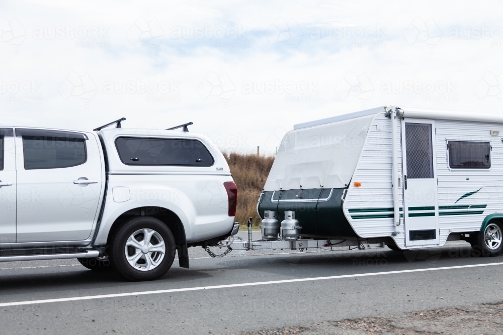 Car pulling a caravan along highway on long weekend holiday - Australian Stock Image