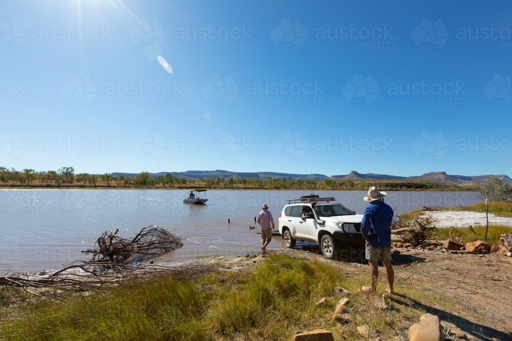 Car reversing boat trailer down boat ramp - Australian Stock Image