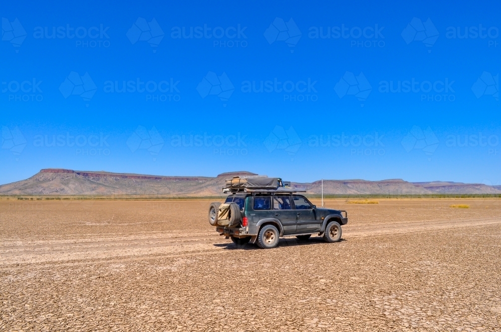 Car traveling on a dry lake bed - Australian Stock Image