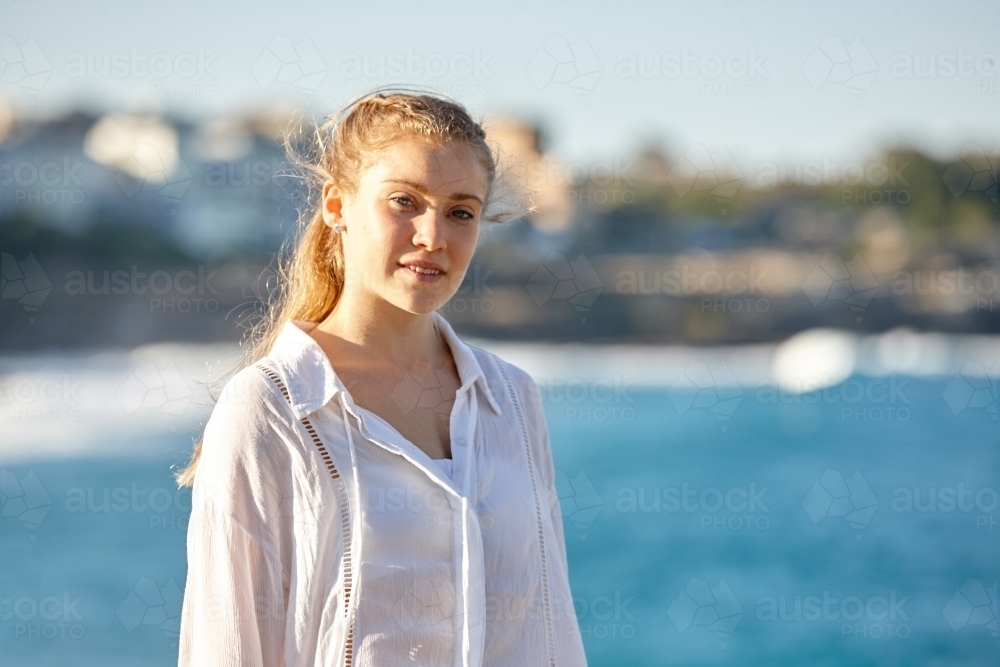 Carefree young blonde-haired woman at beach enjoying the sunshine - Australian Stock Image