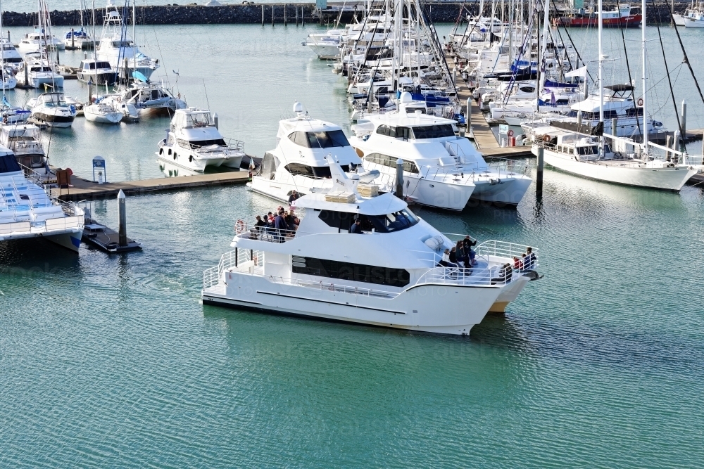 Catamaran leaving marina with whale watching tourist group from Hervey Bay - Australian Stock Image