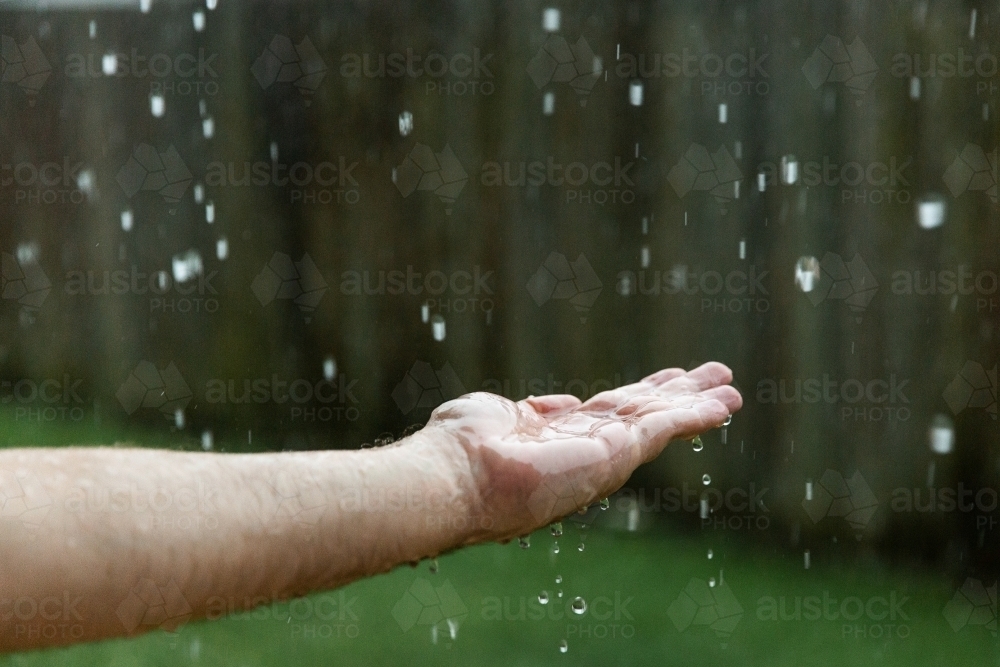 catching rain in a hand - Australian Stock Image