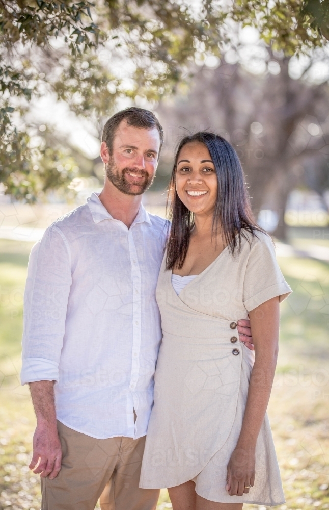 Caucasian husband standing with arm around aboriginal wife - Australian Stock Image