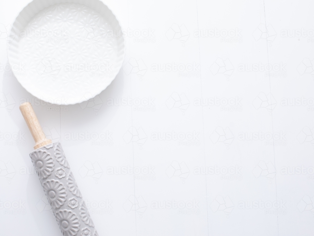 Ceramic pie dish and rolling pin on blank background - Australian Stock Image