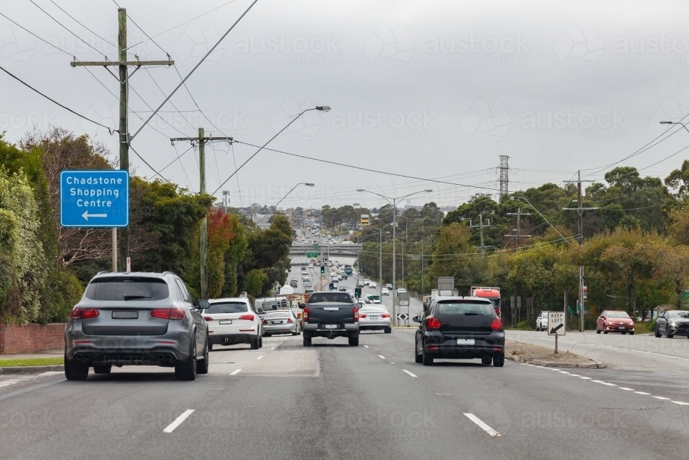 Chadstone shopping centre directions sign on roadside with busy traffic in city multi lane road - Australian Stock Image